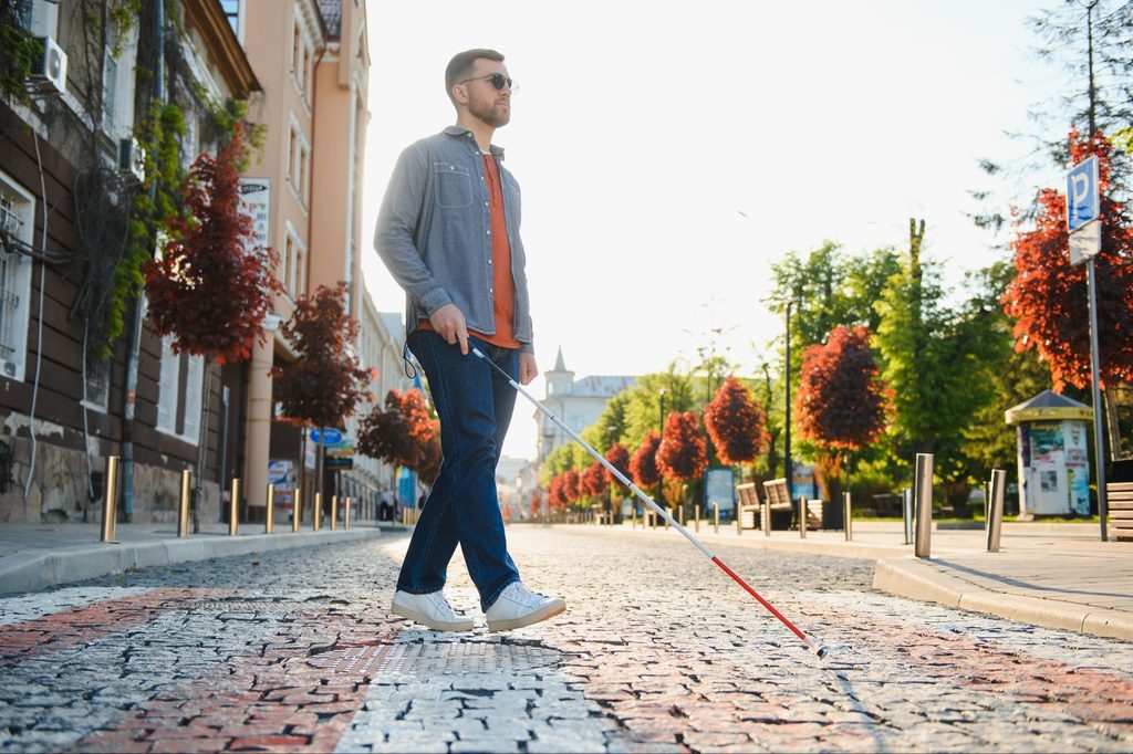 Man using white cane to navigate his surroundings
