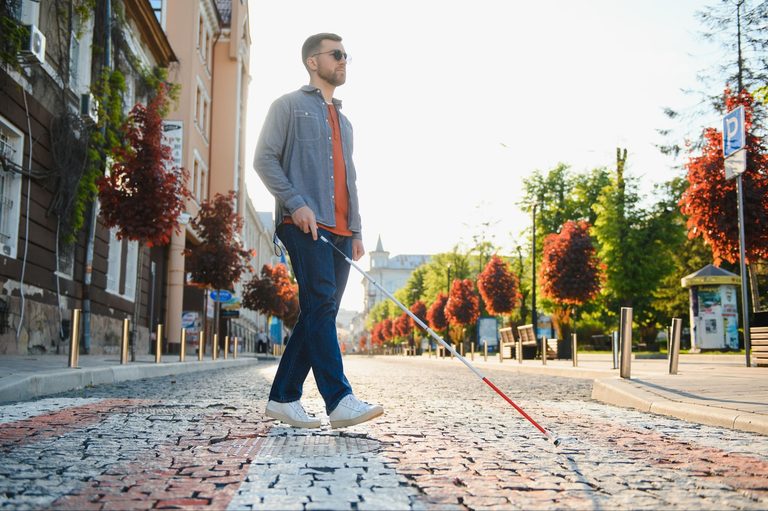 Man using white cane to navigate his surroundings