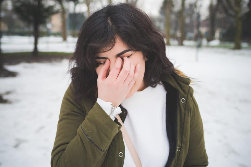 young-hispanic-woman-covering-face-with-hand