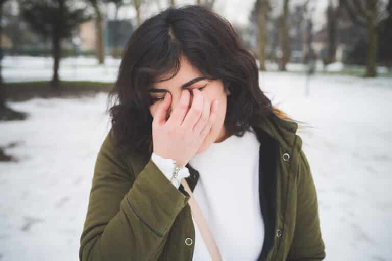 young-hispanic-woman-covering-face-with-hand